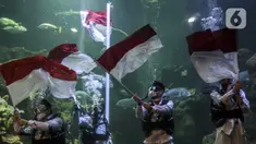Penyelam mengibarkan bendera Merah Putih saat gladi resik HUT ke-75 RI dalam akuarium Sea World Ancol, Jakarta, Sabtu (15/8/2020). Taman Impian Jaya Ancol akan memperingati HUT ke-75 RI dengan mengibarkan bendera Merah Putih dalam akuarium Sea World pada 17 Agustus 2020. (Liputan6.com/Johan Tallo)