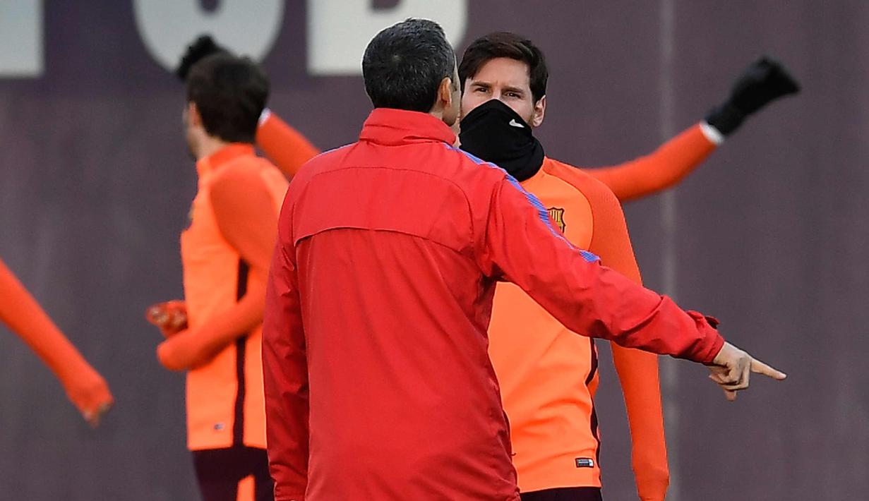 Penyerang Barcelona, Lionel Messi berbincang dengan pelatih Ernesto Valverde saat latihan di Joan Gamper Sports Center di Sant Joan Despi, Spanyol (13/3). Barcelona akan melawan Chelsea pada leg kedua babak 16 besar Liga Champions. (AFP Photo/Lluis Gene)