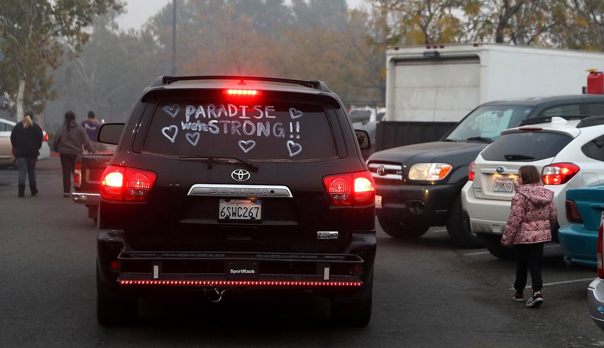 Sebuah mobil dengan kata-kata 'Paradise Strong' terlihat di kaca pusat pengungsian di tempat parkir Walmar, Chico, California (16/11). 631 orang masih hilang akibat musibah kebakaran tersebut. AFP Photo/Justin Sullivan)