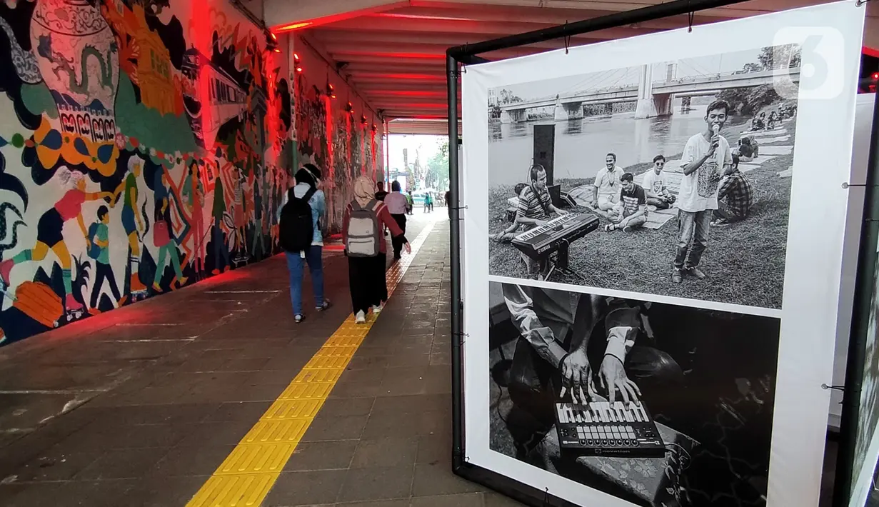 Warga mengamati karya dalam pameran foto cerita Hari Hak Asasi Manusia 2022 di Terowongan Kendal, Jakarta Pusat, Senin (5/12/2022). Tema dari pameran ini adalah inklusi disabilitas, hak masyarakat adat melalui pelestarian bahasa asli, dan bioskop bisik. (Liputan6.com/Magang/Aida Nuralifa)