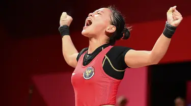 Reaksi lifter putri Indonesia Windy Cantika Aisah usai bertanding dalam cabang angkat besi nomor 49 kg Putri Grup A Olimpiade Tokyo 2020 di Tokyo International Forum, Sabtu (24/7/2021). Windy Cantika mempersembahkan medali perunggu dengan total angkatan 194 Kg. (Vincenzo PINTO/AFP)