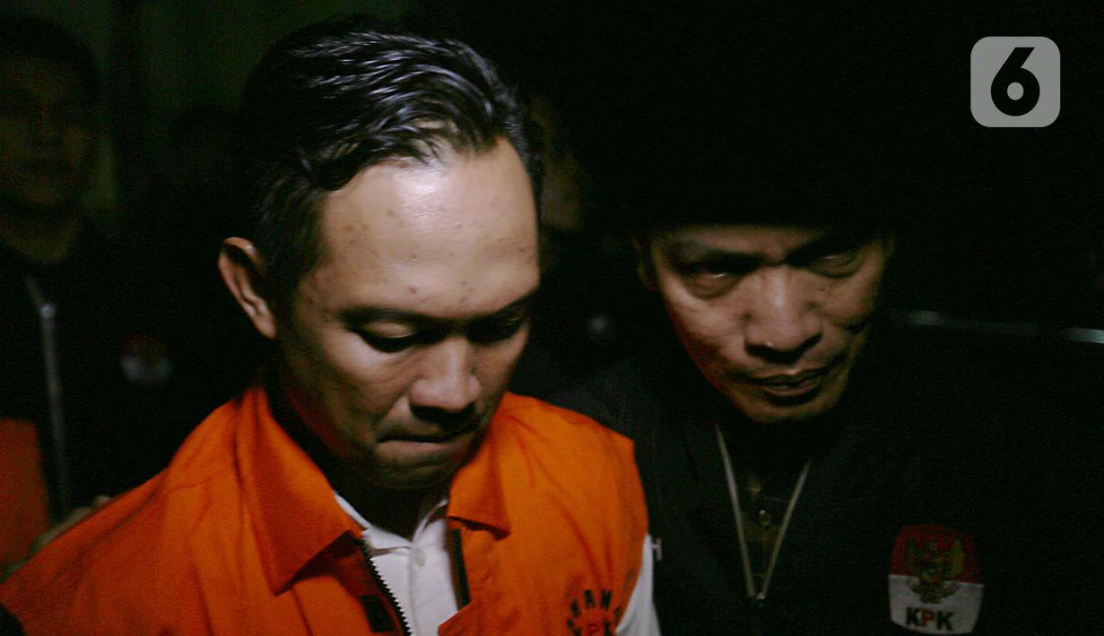 Bupati Cilacap, Jawa Tengah, Syamsul Auliya Rachman saat digiring petugas menuju mobil tahanan di Gedung Merah Putih Komisi Pemberantasan Korupsi (KPK), Jakarta, Sabtu (14/3/2026). Komisi Pemberantasan Korupsi (KPK) resmi menahan dua tersangka terkait dugaan pemerasan dan penerimaan lainnya di lingkungan Pemerintah Kabupaten Cilacap, Jawa Tengah. (Liputan6.com/Helmi Fithriansyah)