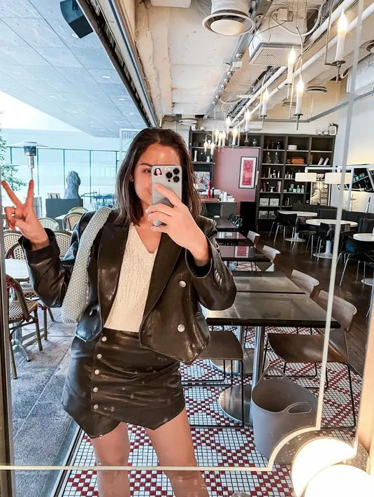 Masih berwarna monokrom, Jessica Iskandar padukan outfit lateksnya dengan t-shirt putih dan shoulder bag [@inijedar]