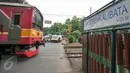 Kereta commuter melintas di perlintasan jalur Kalibata, Jakarta, Jumat (4/12). Untuk menekan angka kecelakaan, Pemprov DKI Jakarta berencana membangun flyover diperlintasan kereta api. (Liputan6.com/Yoppy Renato)