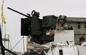 Seorang penjaga perdamaian PBB asal Prancis duduk di atas kendaraan lapis baja di jalan yang digunakan warga mengungsi untuk kembali ke desa mereka pada hari kedua gencatan senjata antara Hizbullah dan Israel di Qasmiyeh, dekat Tyre, Lebanon selatan, Sabtu, (18/5/2026). (Dok. AP/Bilal Hussein)