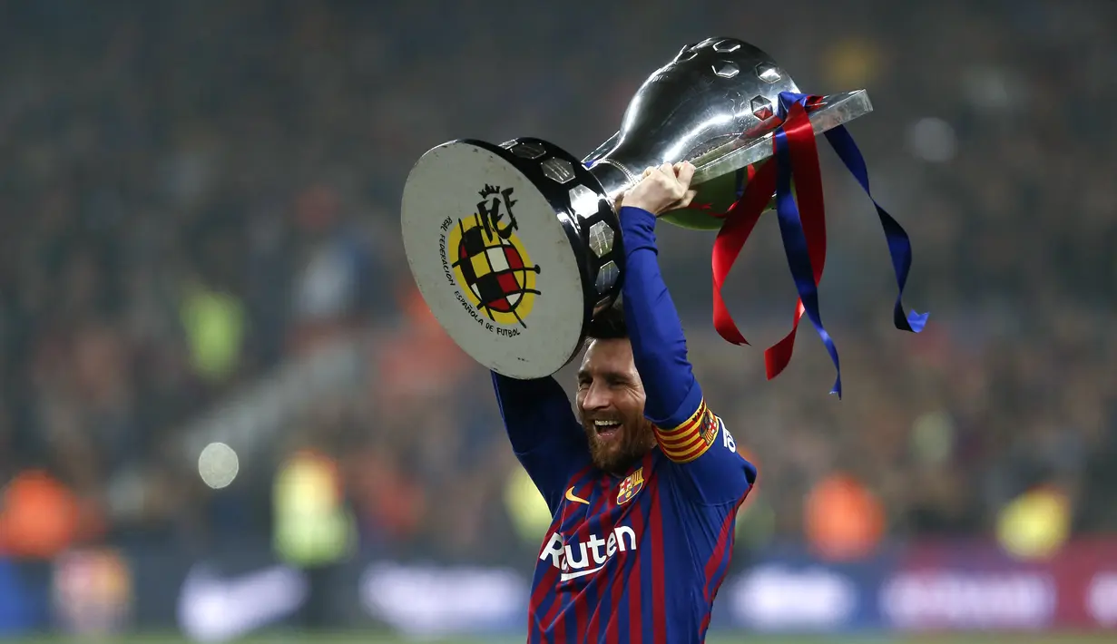 Penyerang Barcelona Lionel Messi mengangkat trofi Liga Spanyol usai memenangkan gelar liga ke-26 mereka setelah pertandingan melawan Levante di stadion Camp Nou di Barcelona pada 27 April 2019. Belum diketahui ke mana Messi akan berlabuh pada musim panas ini. (AFP/Pau Barrena)