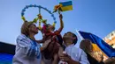 Satu keluarga Ukraina yang tinggal di Chile menghadiri demonstrasi pada peringatan satu tahun invasi Rusia ke Ukraina di Santiago, Chile, 24 Februari 2023. (AP Photo/Esteban Felix)