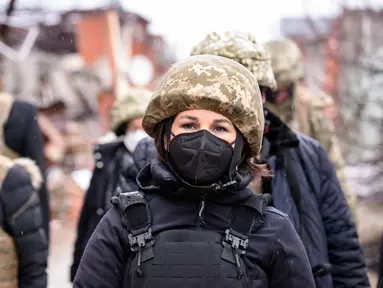 Menteri Luar Negeri Jerman Annalena Baerbock (kanan) terlihat mengenakan helm dan rompi anti peluru saat berkunjung di Shyrokyne, Wilayah Donetsk, Ukraina (8/2/2022). Annalena Baerbock berada di daerah itu selama sekitar 40 menit. (AFP/Pool/Bernd von Jutrczenka)