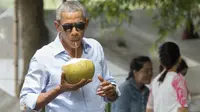 Barack Obama saat menikmati air kelapa di sepanjang Sungai Mekong di Luang Prabang, Laos (7/9). Obama menjadi presiden AS pertama yang mengunjungi Laos dan mendarat di Vientiane akhir pada 5 September. (AFP PHOTO/SAUL Loeb)