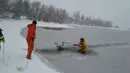 Petugas pemadam kebakaran dari West Metro Fire Rescue menarik kedua tanduk rusa untuk melepaskannya dari dalam danau es di Colorado, AS, Senin (22/1). Dengan pengait di tangannya, dia mengikatkan tali ke tanduk rusa. (facebook.com/WestMetroFireRescue)
