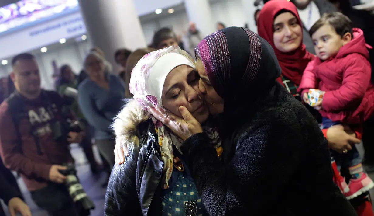 Pengungsi asal Suriah Baraa Haj Khalaf, disambut oleh ibunya Fattuom Bakir saat tiba di bandara Internasional O'Hare, AS, Rabu (7/2). Baraa dan keluarganya harus menjalani introgasi panjang agar bisa melewati otoritas bandara. (AFP Photo/ Scott Olson)