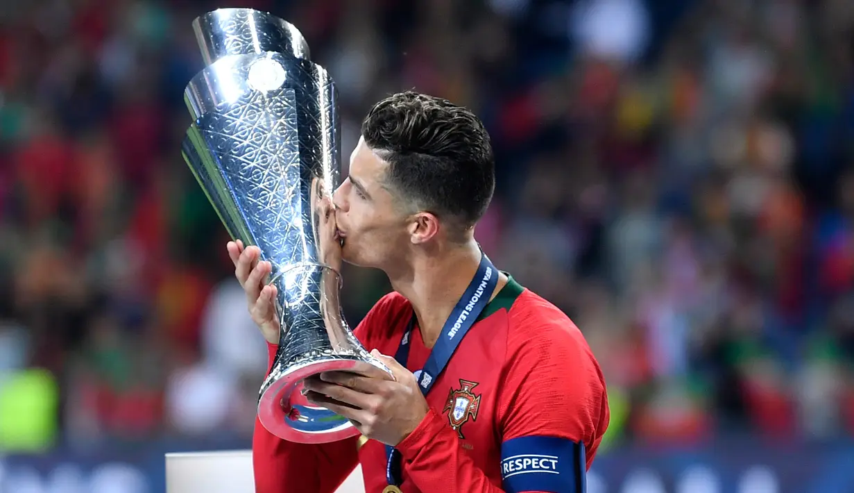 Penyerang Portugal, Cristiano Ronaldo mencium Piala UEFA Nations League setelah pertandingan final melawan Belanda di Estadio do Dragao, Porto (10/6/2019). Portugal berhasil mengalahkan Belanda 1-0, berkat gol Goncalo Guedes. (AP Photo/Martin Meissner)