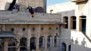 Dua pemuda melompat berlatih parkour di Aleppo, Suriah, (7/4). Setelah pemerintah Suriah mengambil alih kendali penuh Aleppo dari pasukan pemberontak Desember 2016, beberapa pemuda kini menyalurkan hobinya, yaitu parkour.  (AFP Photo/George Ourfalian)