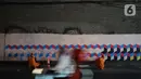 Petugas Penanganan Prasarana dan Sarana Umum (PPSU) Kelurahan Tebet Timur mempercantik tembok kolong jembatan Stasiun Kereta Api Cawang dengan membuat mural bernuansa kemerdekaan di Jakarta, Rabu (12/8/2020). Pembuatan mural untuk menyambut HUT ke-75 Kemerdekaan RI. (Liputan6.com/Immanuel Antonius)