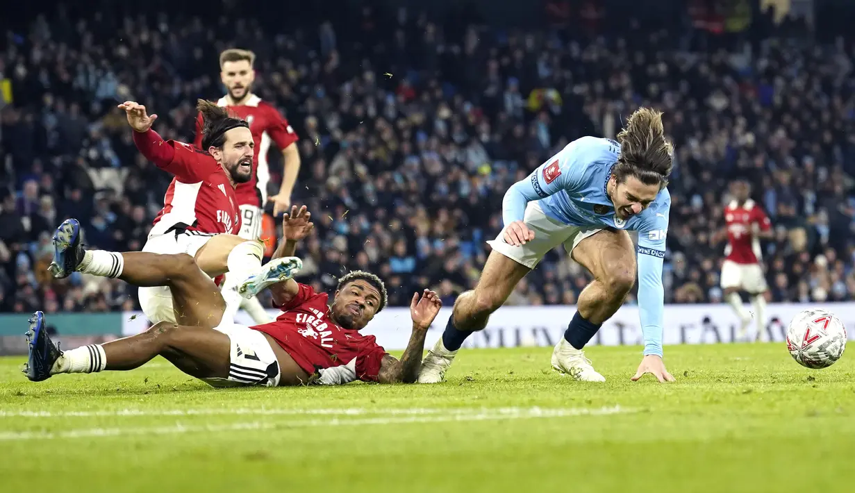 Pemain Manchester City, Jack Grealish (kanan) berusaha melewati penjagaan sejumlah pemain Salford City pada laga lanjutan Piala FA 2024/2025 di Etihad Stadium, Manchester, Inggris, Minggu (12/01/2025). (AP Photo/Dave Thompson)