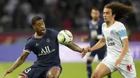 Bek Paris Saint-Germain (PSG) Presnel Kimpembe berebut bola dengan gelandang Olympique Marseille Matteo Guendouzi pada laga Liga Prancis pekan ke-32 di Parc des Princes, Senin (18/4/2022) dini hari WIB. PSG vs Marseille berakhir dengan skor 2-1. (AP Photo/Francois Mori)