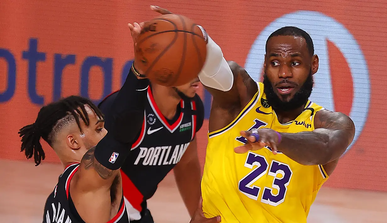 Pebasket Los Angeles Lakers, LeBron James, berebut bola dengan pebasket Portland Trailblazers,  Gary Trent Jr, pada babak pertama playoff NBA 2020 di AdventHealth Arena, Rabu (19/8/2020). LA Lakers takluk 93-100 atas Portland Trailblazers. (AFP/Mike Ehrmann/Getty Images)