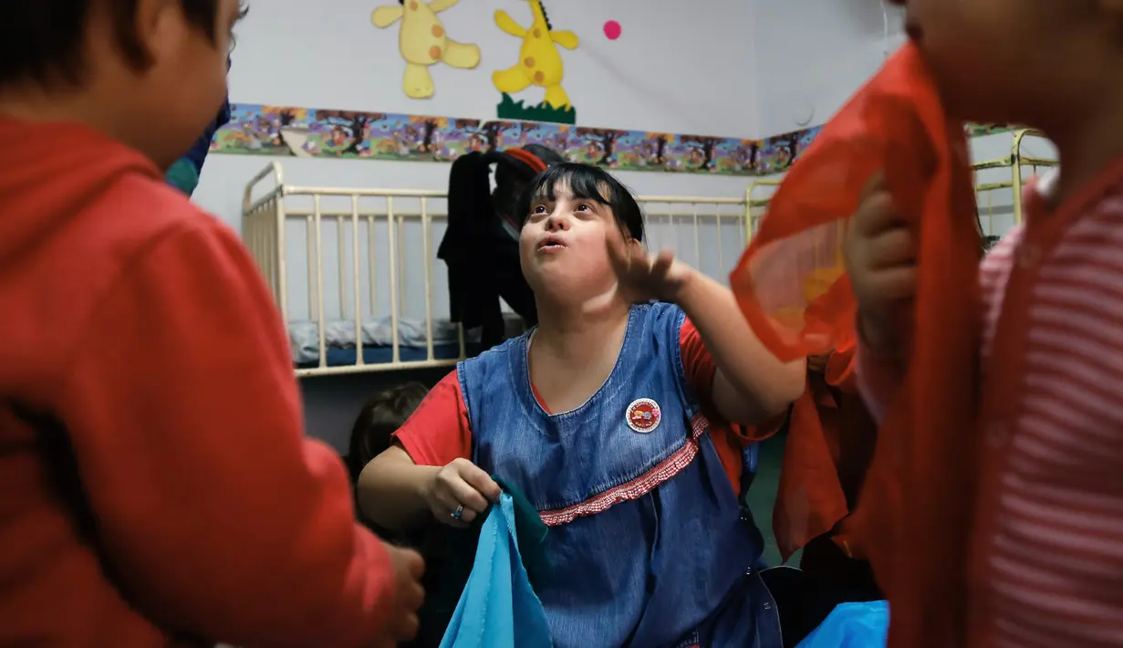 Noelia Garella bermain dengan muridnya di TK Jeromito, Argentina (24/10). Keinginan Noelia menjadi guru TK berawal dari masa kecil yang pahit saat dirinya ditolak masuk ke sebuah sekolah, bahkan dirinya disebut 'Monster'. (AFP Photo/Diego Lima)