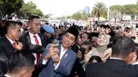 Presiden Joko Widodo atau Jokowi yang menggelar open house di Istana Negara, keluar untuk berfoto bersama warga, Rabu (6/5/2019) (Liputan6/Lizsa Egeham)