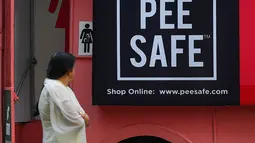 Foto pada 9 Februari 2020 menunjukkan seorang perempuan  berjalan melewati toilet keliling di sebuah bus di taman umum di Pune, India. Proyek Ti Toilet, sebuah bus yang diubah menjadi toilet dan diluncurkan pada tahun 2016, adalah gagasan Ulka Sadalkar dan Rajeev Kheer. (Indranil MUKHERJEE/AFP)