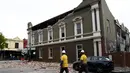 Petugas darurat dan penyelamatan memeriksa bangunan yang rusak setelah gempa di pusat perbelanjaan populer Chapel Street di Melbourne, Rabu (22/9/2021). Gempa magnitudo 5,8 melanda dekat Melbourne dan guncangannya terasa di sejumlah wilayah di Australia pada Rabu pagi. (William WEST/AFP)