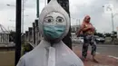 Patung bermasker terlihat di pinggiran Kali Kanal Barat, Cakung, Jakarta, Kamis (25/2/2021). Pemerintah terus berupaya mengampanyekan penggunaan masker kepada masyarakat di tengah kasus virus corona COVID-19 yang terus meningkat. (merdeka.com/Imam Buhori)