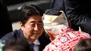 PM Jepang Shinzo Abe menyapa korban selamat Pearl Harbor setelah menyampaikan pidato dengan Presiden AS Barack Obama di Joint Base Pearl Harbor-Hickam, Hawaii, (27/12). (REUTERS/Kevin Lamarque)