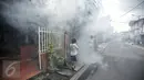 Seorang anak menutup hidungnya saat dilakukan pengasapan (Fogging) di kelurahan Menteng, Jakarta, Senin (8/2). Pengasapan dilakukan untuk mencegah wabah penyakit demam berdarah yang kerap muncul pada peralihan musim. (Liputan6.com/Faizal Fanani)