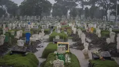 Keluarga memasang hiasan dari besi bertuliskan ”My Love” di sebuah pusara di lahan khusus korban Covid-19 di TPU Keputih, Surabaya, Jawa Timur, Kamis (7/1/2020). Kasus penyebaran Covid-19 di Surabaya masih tinggi.  (AFP/Juni Kriswanto)