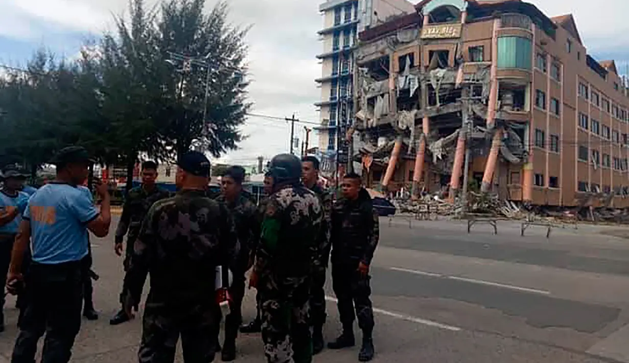 Polisi mengamankan area dekat Hotel Eva yang rusak usai gempa bumi kuat di Kidapawan, provinsi Cotabato utara, Kamis (31/10/2019). Gempa bumi kembali mengguncang Filipina selatan, kali ini bermagnitudo 6,5 dan merupakan gempa kuat ketiga yang berpotensi menimbulkan kerusakan. (AP/Williamor Magbanua)