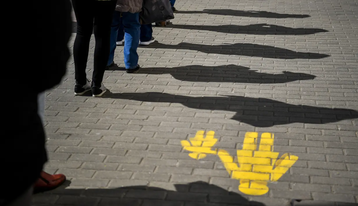 Warga melakukan social distancing atau menjaga jarak saat mengantre di depan kantor pos di Debrecen, Hungaria, Senin (16/3/2020). Social distancing adalah cara terbaik untuk mencegah penyebaran virus corona COVID-19. (Zsolt Czegledi/MTI via AP)
