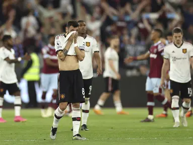 Gelandang Manchester United, Bruno Fernandes (tengah) menutupi wajahnya setelah pertandingan melawan West Ham United pada pertandingan lanjutan Liga Inggris di Stadion London di London, Inggris, Senin, 8 Mei 2023. (AP Photo/Ian Walton)
