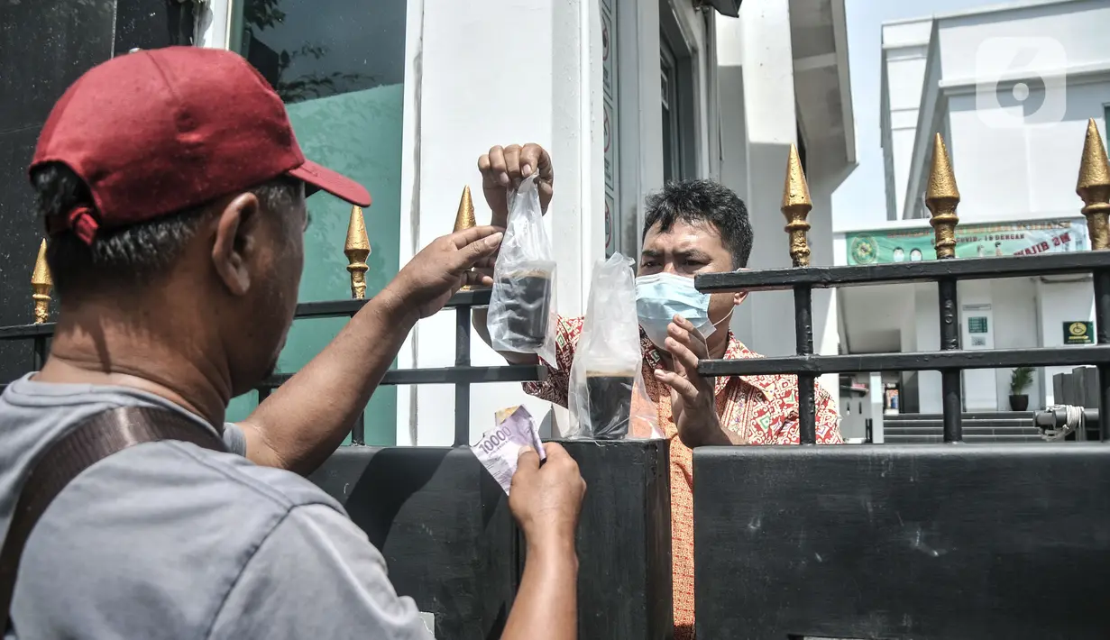 Pegawai saat membeli makanan melalui salah satu pagar gedung PN Jakarta Barat, Kamis (27/1/2022). Penutupan dimulai pada 27-31 Januari 2022 dan akan dibuka kembali pada 2 Februari 2022. (Merdeka.com/Iqbal S. Nugroho)