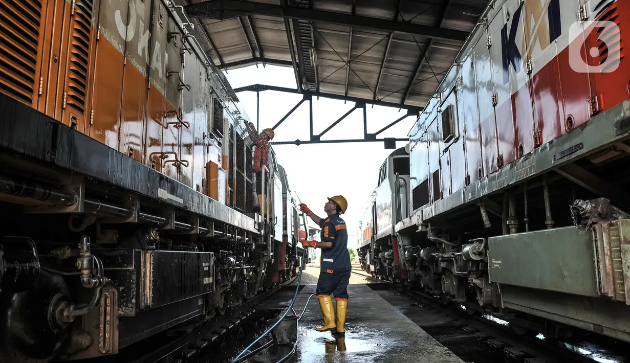 Petugas saat mencuci lokomotif kereta jarak jauh di Depo KA Cipinang, Jakarta Timur, Selasa (6/9/2022). Perawatan rutin itu terdiri atas tiga kategori antara lain pemeriksaan harian, bulanan, dan tahunan. (merdeka.com/Iqbal S Nugroho)