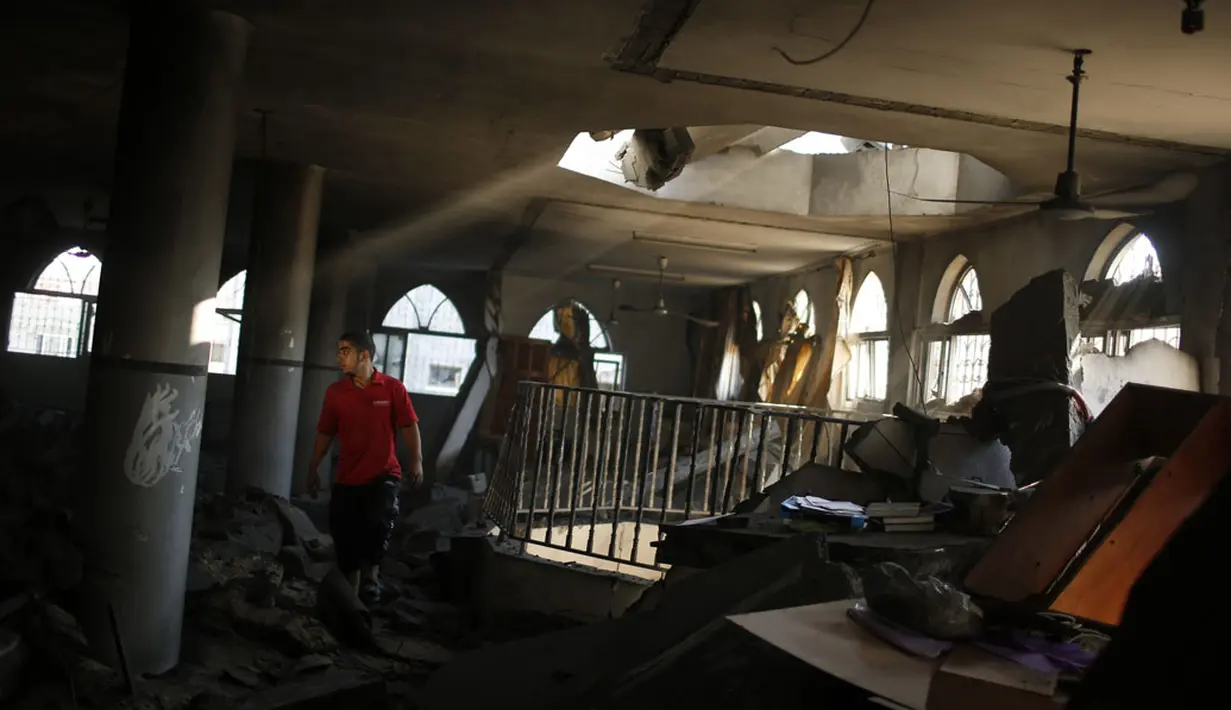 Salah satu warga memeriksa kondisi sebuah masjid di kota gaza yang hancur akibat serangan udara militer Israel, (9/8/2014). (REUTERS/Mohammed Salem)