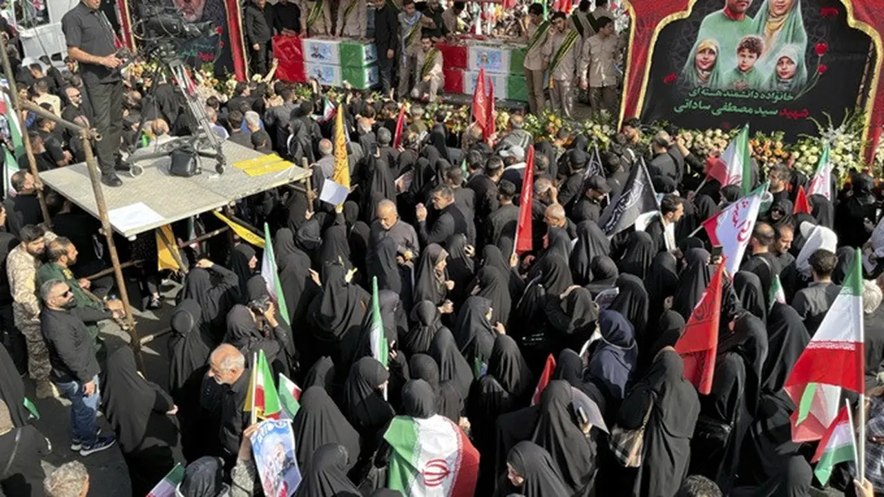 Orang-orang berduka di antara peti jenazah para elite militer Iran, ilmuwan nuklir, dan anggota keluarga mereka yang tewas dalam serangan Israel, selama upacara pemakaman di Teheran, Sabtu (28/6/2025).
