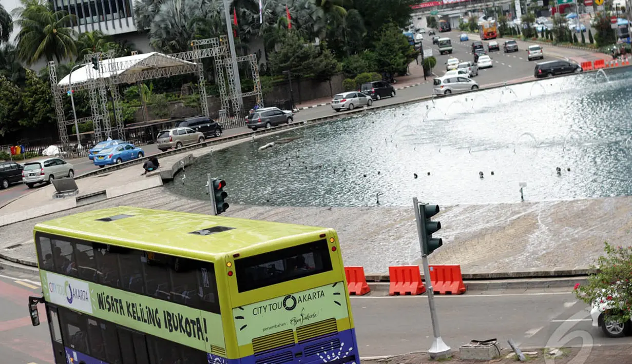 Sebuah bus tingkat wisata tampak melintasi kawasan Bundaran HI, Jakarta, Kamis (1/1/2015). (Liputan6.com/Faizal Fanani)