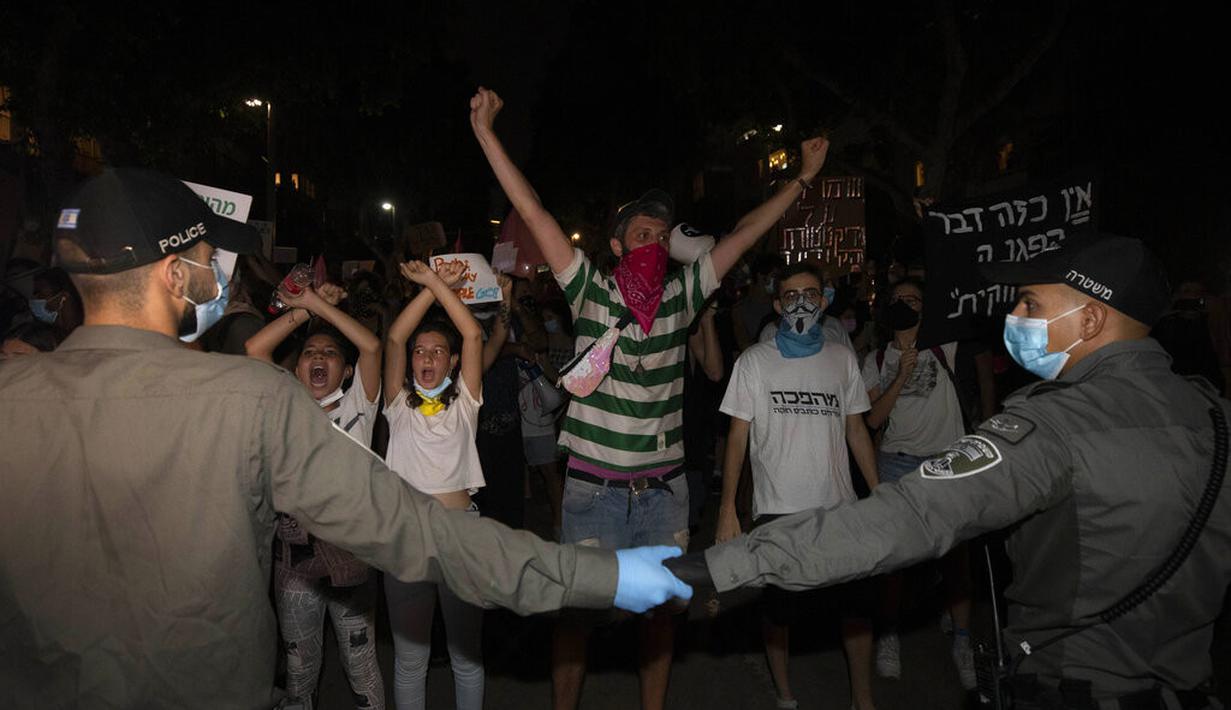 Polisi memblokir pengunjuk rasa selama demonstrasi menentang tindakan lockdown di Tel Aviv, Israel, Kamis (1/10/2020). Pengunjuk rasa meyakini lockdown ditujukan untuk mengekang protes terhadap Perdana Menteri Israel Benjamin Netanyahu. (AP Photo/Sebastian Scheiner)