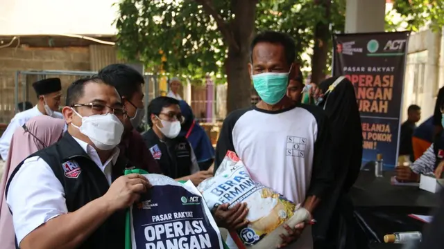 Presiden ACT Ibnu Khajar (kiri) saat memberikan paket sembako dalam Operasi Pangan Murah di Masjid Assuada, Kecamatan Koja, Jakarta Utara, Jumat (15/10/2021).