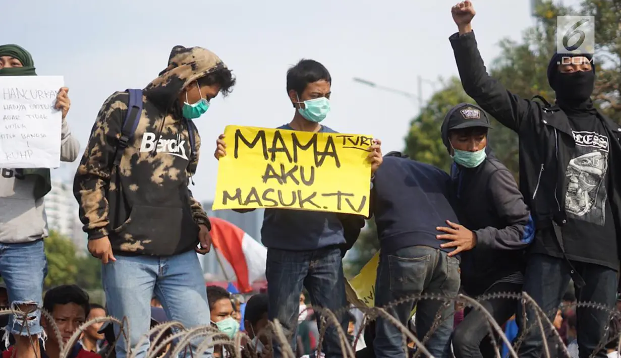 Massa aksi yang tergabung dari elemen mahasiswa, buruh, dan pelajar membawa spanduk dalam unjuk rasa di depan Gedung DPR RI, Jakarta, Senin (30/9/2019). Aksi unjuk rasa tersebut menyikapi penolakan terhadap UU KPK dan sejumlah RUU yang dinilai bermasalah. (Liputan6.com/Immanuel Antonius)