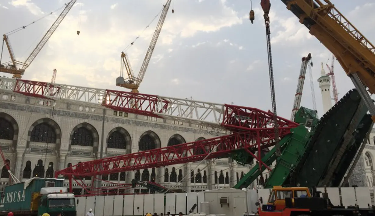 Pekerja dibantu alat berat berusaha mengevakuasi crane yang roboh di Masjidil  Haram, Kota Mekah,  Arab Saudi (9/12/2015). Sebanyak 107 calon jemaah haji meninggal dunia akibat crane jatuh karena cuaca buruk. (AFP PHOTO / STR)
