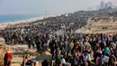 Orang-orang berjalan di sepanjang Jalan Al-Rashid di wilayah pesisir untuk menyeberangi koridor Netzarim dari Jalur Gaza selatan ke utara pada 27 Januari 2025. (Omar AL-QATTAA/AFP)