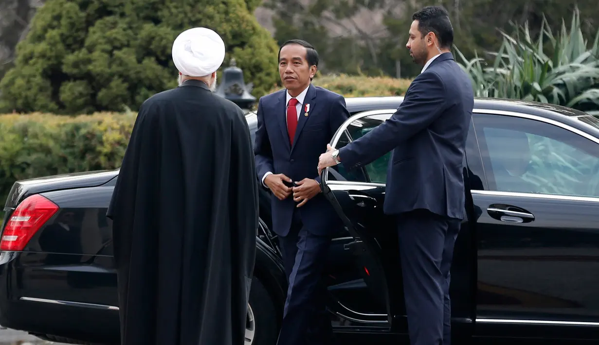 Presiden Joko Widodo disambut Presiden Iran Hassan Rouhani saat tiba di Istana Saadabad, Rabu (14/12). Dalam kunjungannya, Jokowi akan melakukan pertemuan bilateral, penandatanganan nota-nota kesepahaman. (AFP Photo/Atta Kenare) 