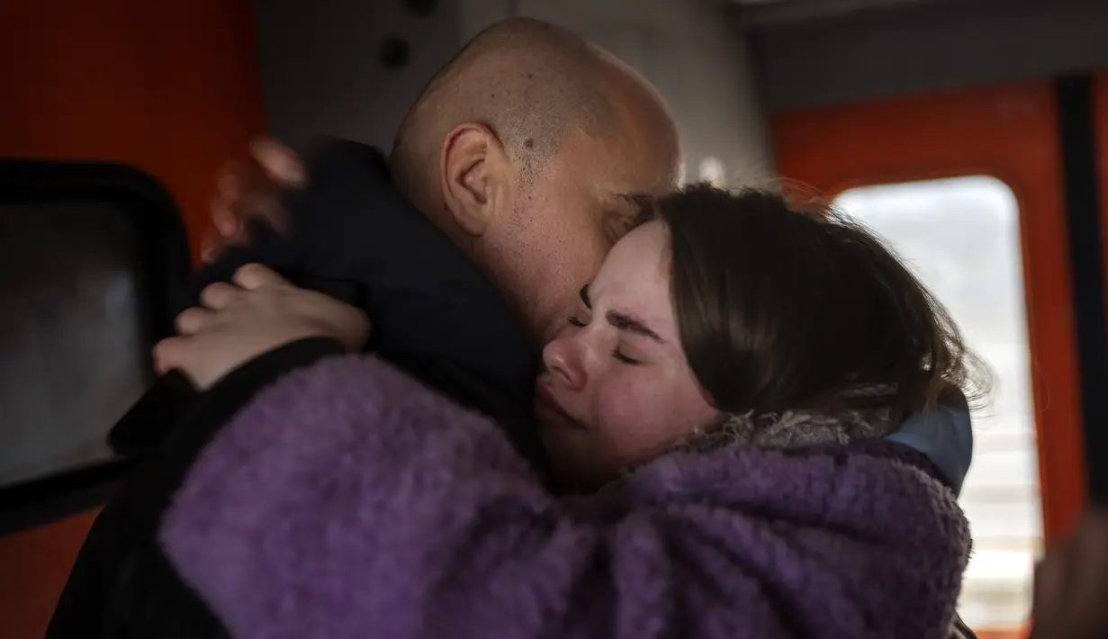 Pasangan mengucapkan selamat tinggal di kereta menuju Lviv di stasiun Kyiv, Ukraina, 3 Maret 2022. Pria Ukraina harus tinggal untuk berperang sementara wanita dan anak-anak meninggalkan negara itu untuk mencari perlindungan di negara tetangga. (AP Photo/Emilio Morenatti)