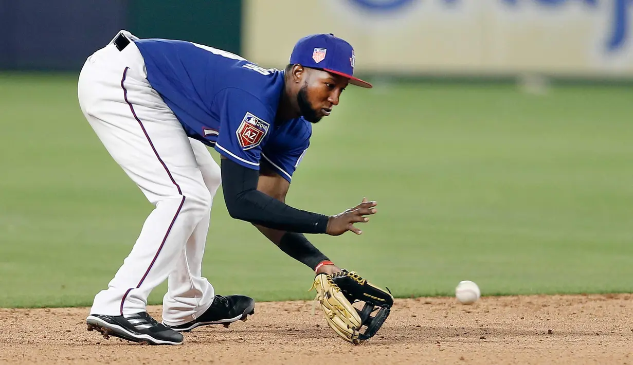 Pemain Texas Rangers, Jurickson Profar (19) berusaha menangkap bola pukulan grounder Cincinnati Reds, Tony Cruz selama inning ketujuh pertandingan bisbol pramusim di Arlington, Texas (26/3). Texas menang 6-5. (AP Photo/Brandon Wade)