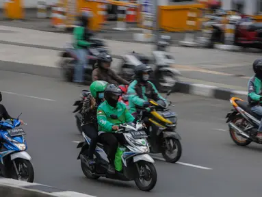 Sejumlah pengemudi ojek online membawa penumpang melintas di kawasan Harmoni, Jakarta, Selasa (7/4/2020). Selama pemberlakuan Pembatasan Sosial Berskala Besar (PSBB), layanan ojek online (ojol) akan dilarang mengangkut penumpang dan hanya dibolehkan untuk antar barang. (Liputan6.com/Faizal Fanani)