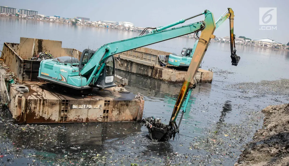 Eskavator dan tongkang Dinas Tata Air DKI Jakarta mengeruk lumpur dan sampah dari Waduk Pluit, Jakarta, Selasa (11/12). Pengerukan ini juga untuk mencegah pertumbuhan eceng gondok yang mengakibatkan pendangkalan Waduk Pluit. (Liputan6.com/Faizal Fanani)