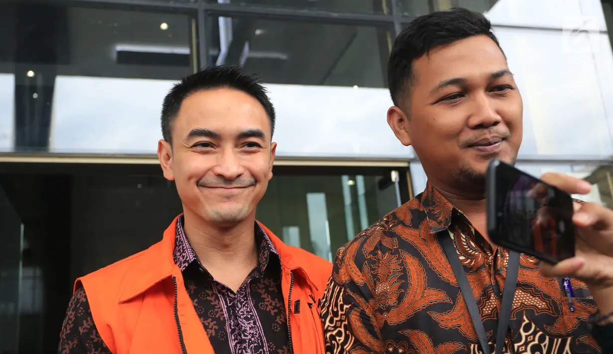 Gubernur Jambi nonaktif, Zumi Zola mengenakan rompi oranye tersenyum usai pemeriksaan di KPK, Jakarta, Jumat (25/5). Zumi diperiksa sebagai saksi untuk tersangka Arfan terkait gratifikasi proyek-proyek di Provinsi Jambi. (Liputan6.com/Herman Zakharia)