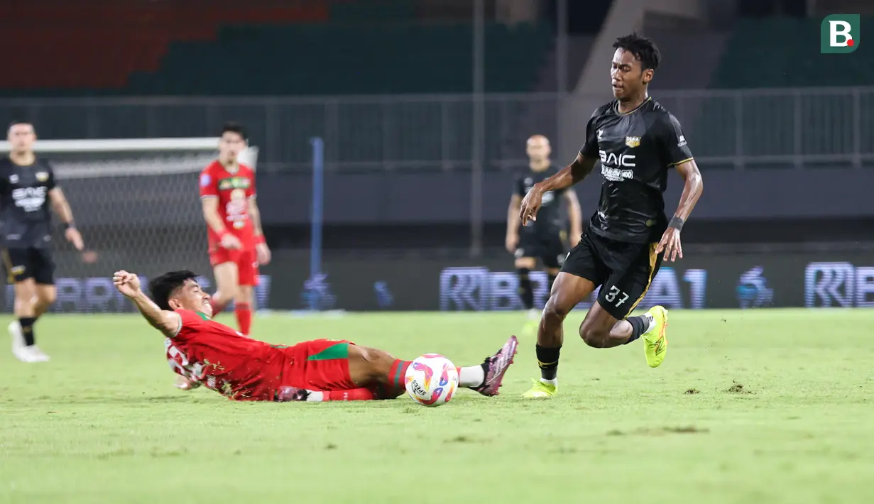 Pemain Dewa United, Alta Balah (kanan) berhasil melewati hadangan pemain Persebaya Surabaya dalam pertandingan Dewa United melawan Persebaya Surabaya pada pekan ke-24 BRI Liga 1 di Stadion Pakansari, Kabupaten Bogor, Jumat (21/2/2025) malam WIB. (Bola.com/Abdul Aziz)