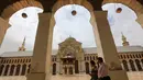 Dua pria Suriah berjalan melintasi masjid bersejarah Umayyad di kota lama Damaskus, Selasa (22/5). Masjid yang juga dikenal sebagai Masjid Agung Damaskus itu merupakan salah satu masjid terbesar dan tertua di dunia. (AFP PHOTO/LOUAI BESHARA)